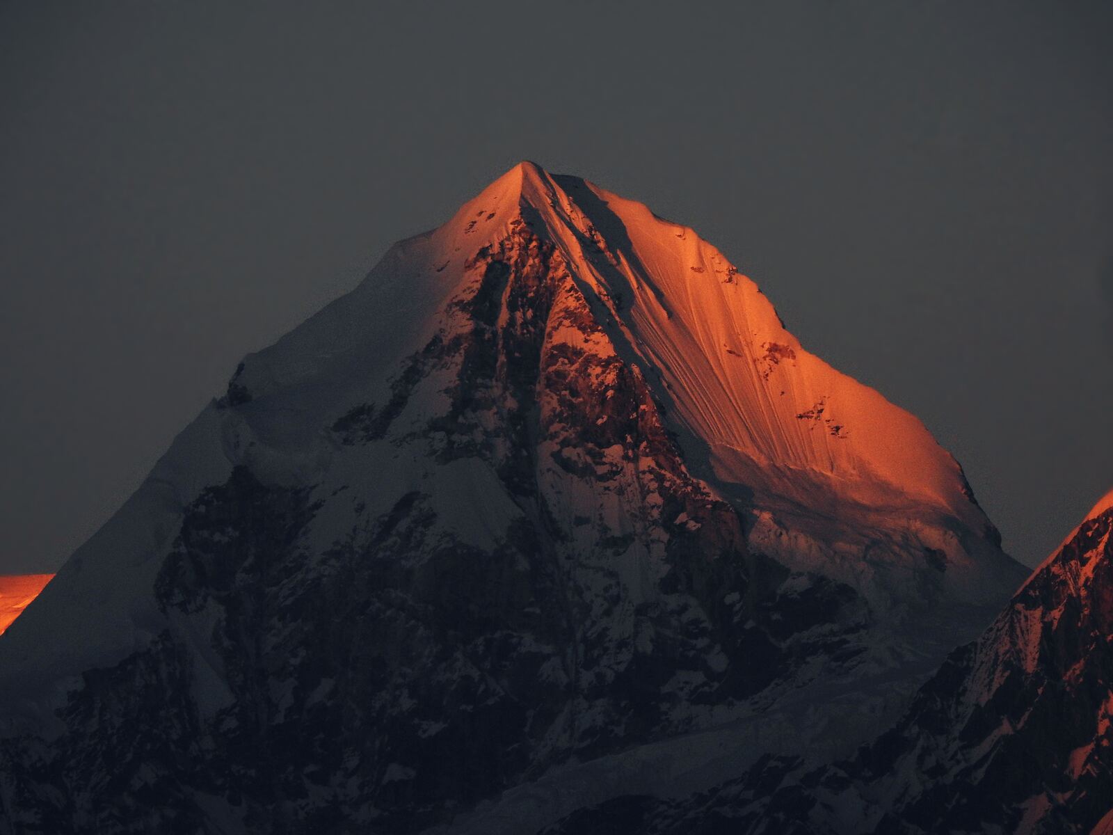 Wide shot: Machhapuchhre at sunrise from the Mardi Himal ridge, the trail running up the grassy crest in the foreground